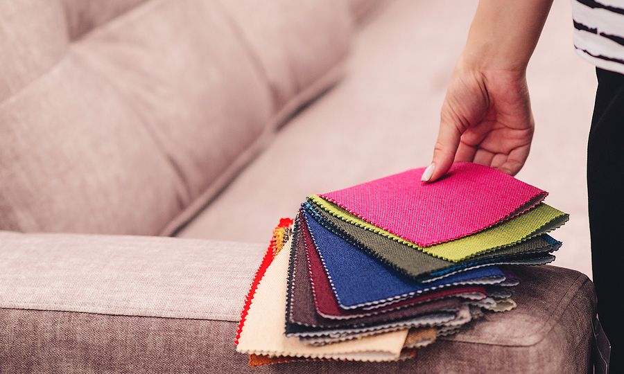 Woman Chooses The Colors And Patterns Of Upholstery Fabrics. Tex