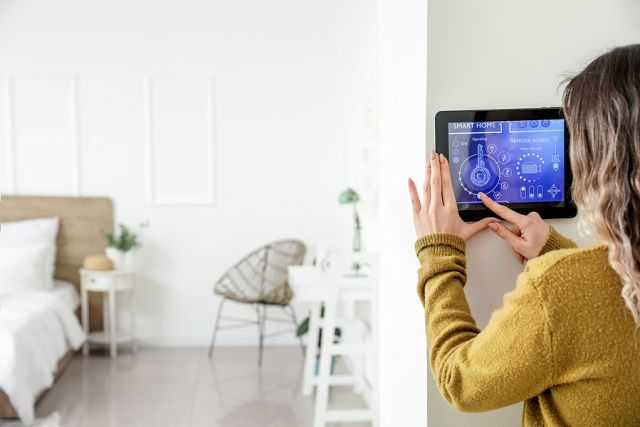 Woman Using Smart Home Security System Control Panel